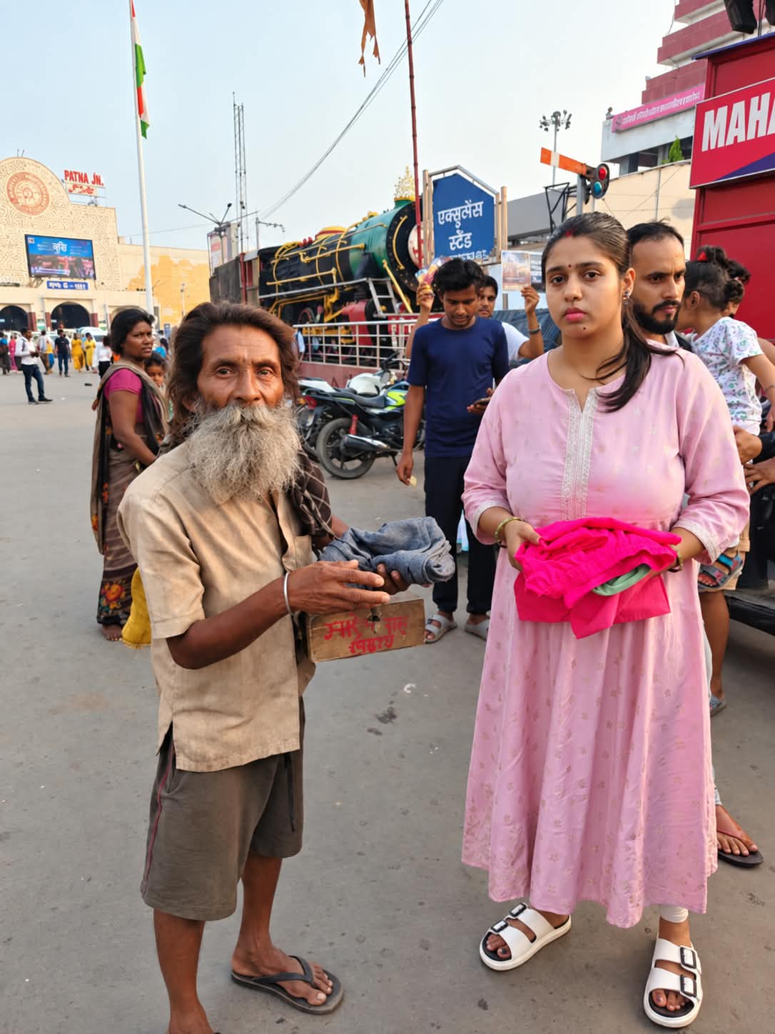 An HCF member handing clothing to a community member near Mahavir Mandir, Patna