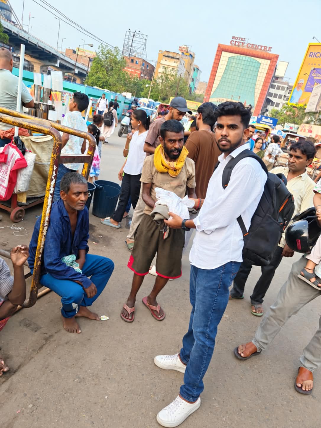 Harit Chetna Foundation members handing collected clothing to a community member on a Patna street
